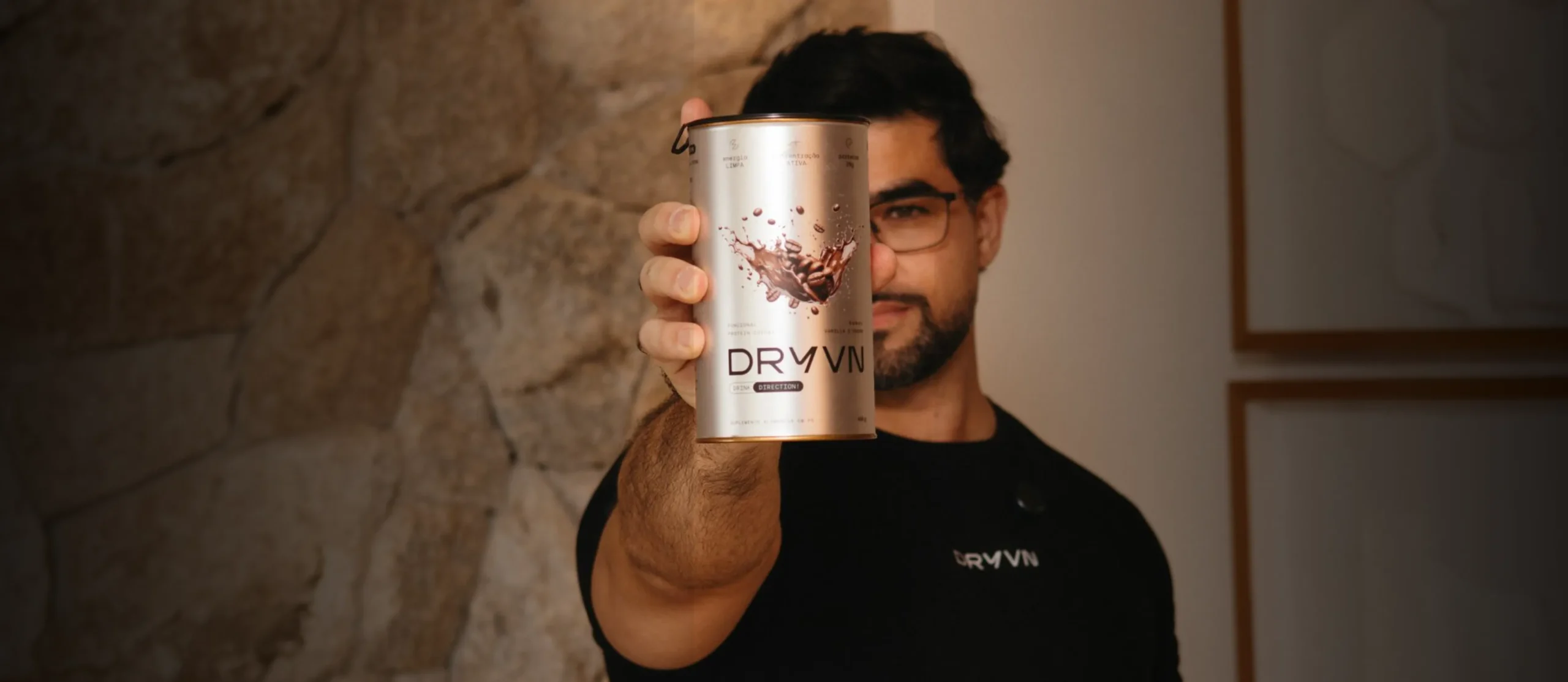 Homem de camiseta DRYVN estendendo a lata de DRYVN em direção à câmera